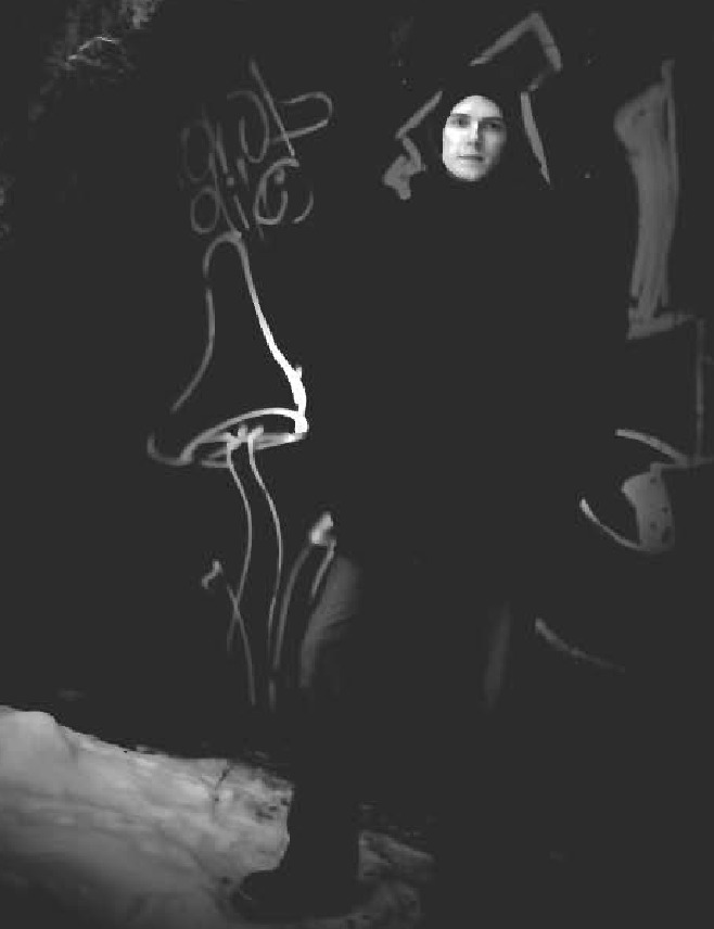 T. M. Mäkelä standing by a graffiti wall at night, snow at his feet